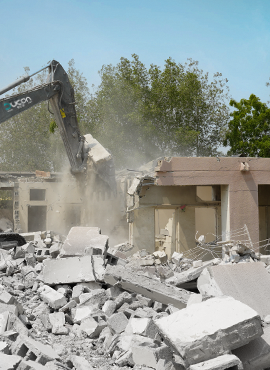 Building demolition in progress with excavator